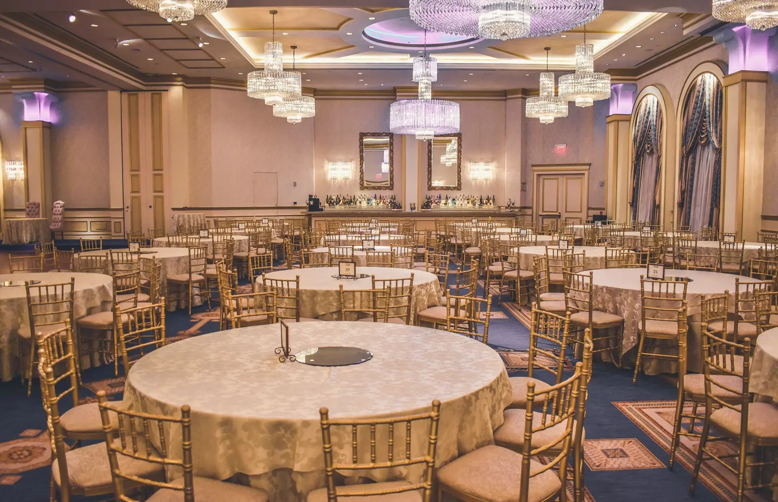 Ballroom set with round tables and chandeliers before a gala dinner