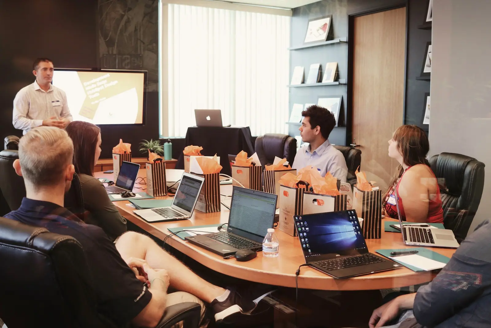 Team gathered around laptops at a long table