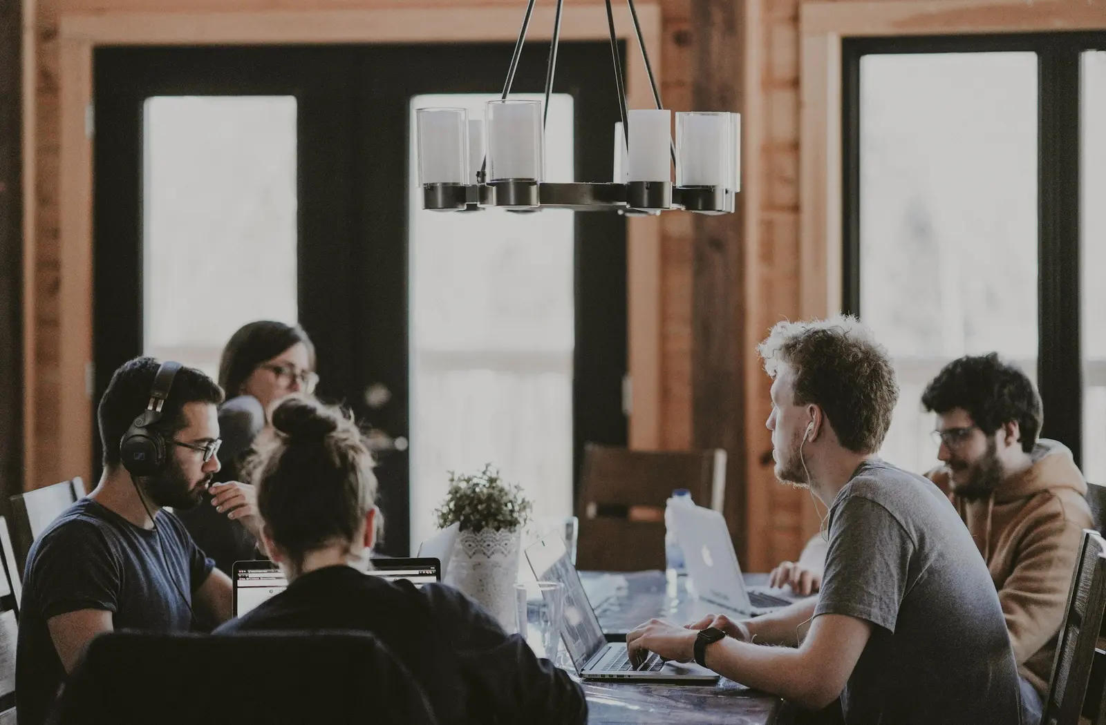 Team leaning over a wooden table during a discussion
